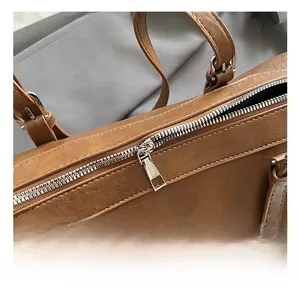 Close-up of premium silver zipper and metallic hardware on vintage brown handbag