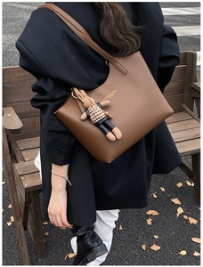 Détail du sac cabas en cuir marron café avec un pendentif lapin à motif pied-de-poule