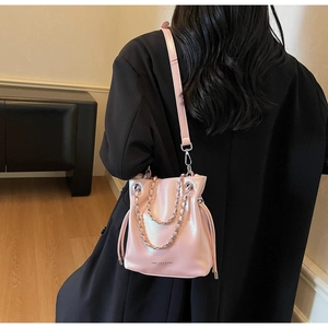 Detail of pink pearlescent bucket bag with silver chain and adjustable strap