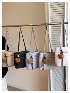 Detail of minimalist tote bags in five colors with cute bear and fringe charm accents