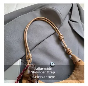 Détail du sac à bandoulière en daim marron vintage montrant la bandoulière réglable