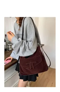 Detail of vintage dark brown suede hobo bag with magnetic flap pocket and shoulder straps
