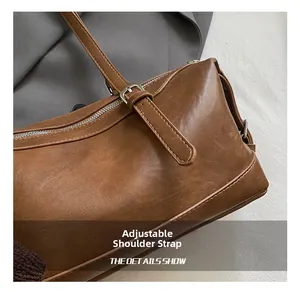 Close-up of adjustable brown leather shoulder strap with silver metal buckle on retro bag
