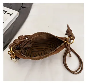 Detail view of brown leopard bag with striped lining and knot shoulder strap