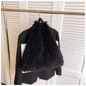 Detail of fluffy black plush tote bag hanging on a rack for a winter fashion look