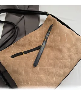 Detail of earth brown quilted suede shoulder bag with gold hardware and leather strap