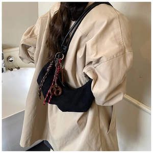Détail du sac hobo en daim noir avec pendentif corde tressée et breloque en biscuit