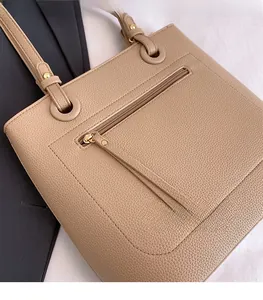 Detailed macro view of beige tote bag showing high-quality lychee grain leather texture
