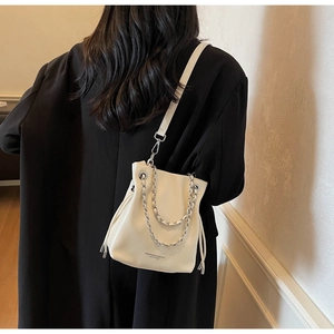 Detail view of the drawstring bucket bag with silver chains and leather shoulder strap