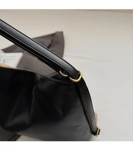 Close-up of premium gold metal hardware on black quilted leather commuter handbag