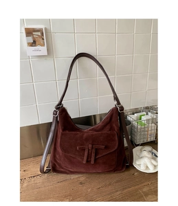 Detail of vintage burgundy suede hobo bag featuring a decorative front knot and adjustable strap