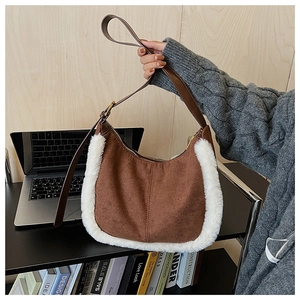 Dettaglio della borsa sottobraccio in camoscio marrone con bordo in ecopelliccia bianca e pelle