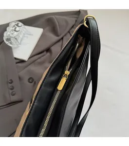 Close-up of smooth gold zipper hardware on premium black quilted leather bag