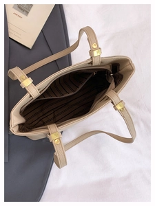Top view of beige tote bag showing spacious striped interior and gold metal buckle