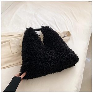 Detailed view of large black plush tote bag with soft faux fur texture and V-shape design