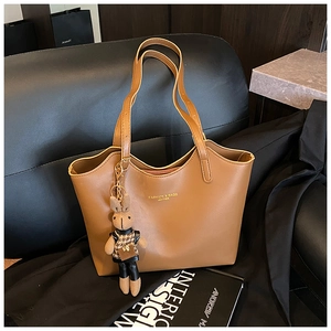 Gros plan du sac fourre-tout vintage marron sur canapé avec un charmant lapin décoratif