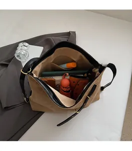 Detail view of large quilted brown tote bag interior with multiple daily items
