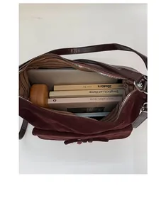 Detailed interior of a vintage burgundy tote bag showing large capacity for laptop and books