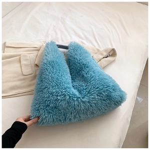 Detail view of large blue fuzzy plush tote bag showing soft faux fur texture and shape