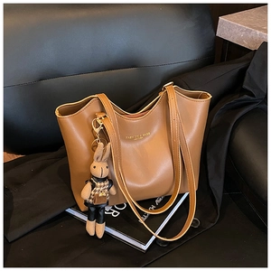 Détail du grand sac cabas en cuir marron vintage avec un charm lapin et logo imprimé