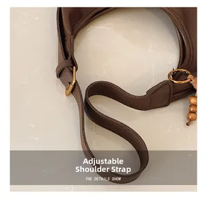 Detail of adjustable leather strap with golden metal buckle and wooden bead accent