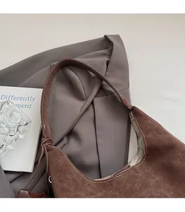 Détail du sac cabas vintage en daim marron foncé avec coutures blanches contrastées