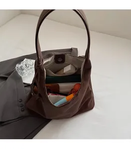 Vue intérieure d'un grand sac hobo marron montrant le compartiment spacieux et la poche zippée