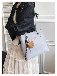 Detailed back view of light gray pebbled leather tote bag with functional zipper pocket