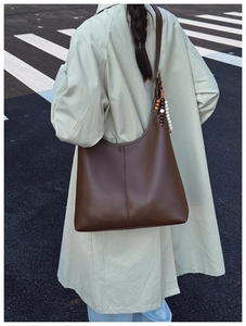 Detailed view of brown leather hobo bag with unique bead accents on the shoulder strap