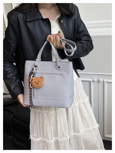 Detail of light purple tote bag with lychee texture and cute bear charm pendant