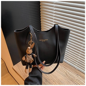 Gros plan sur le sac cabas noir avec lettrage doré et son pendentif lapin fantaisie