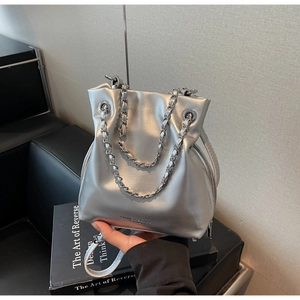 Macro shot of silver pleated bucket bag with metal chain strap and logo detail