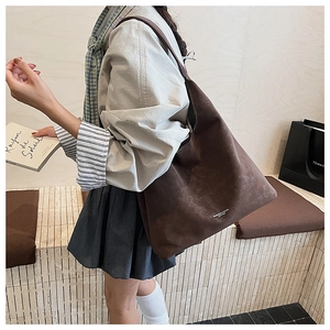 Détail du grand sac cabas en daim marron montrant sa capacité et son drapé souple