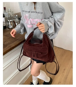 Detailed close-up of dark wine red suede tote bag with stylish bow tie strap detail