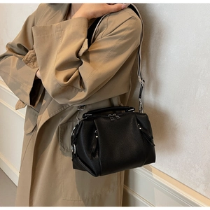 Close-up of black litchi texture doctor bag with contrast wide strap and metal hardware