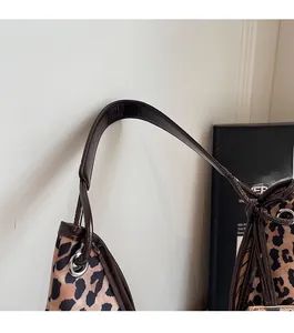 Detail of leopard print nylon bag showing durable shoulder strap with silver eyelets