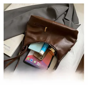 Interior view of large brown leather tote bag showing storage for tablet and essentials