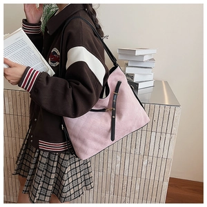 Detailed view of pink quilted hobo bag with contrast straps and retro collegiate design