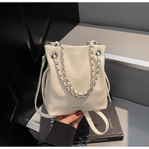Detailed view of off-white bucket bag with silver chain handle and fashion leather text