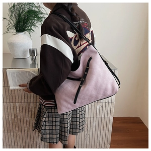 Detail showing pink quilted suede texture and black leather strap on a large tote bag