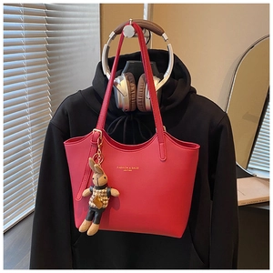Détail du cabas en cuir rouge avec texte doré et un charmant pendentif lapin