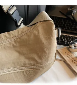 Close-up of khaki nylon shoulder bag showing pleated fabric and adjustable strap