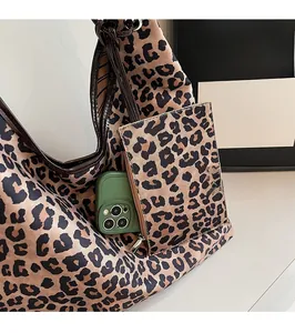 Detail of leopard print nylon tote bag featuring matching pouch and leather handles