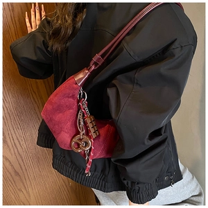 Vue détaillée du sac hobo en daim bordeaux avec charms bretzel et chocolat uniques