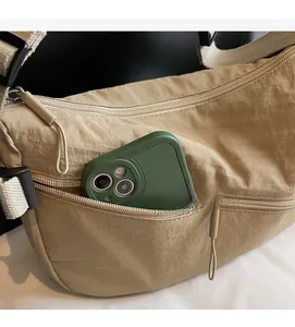 Detail of nylon crossbody bag featuring front zipper pocket and large capacity storage