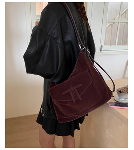 Detail of a vintage dark reddish brown suede hobo bag with unique buckle strap decoration