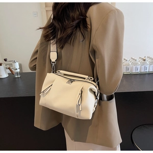 Detail of cream pillow bag featuring lychee texture and adjustable wide fabric strap