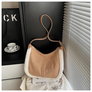 Dettaglio di una borsa a mezzaluna in pelle scamosciata marrone con bordo in ecopelliccia