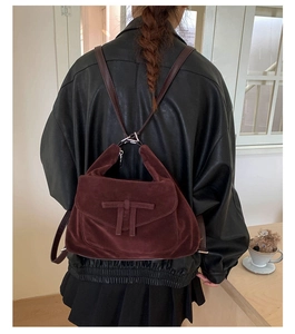 Detail of burgundy velvet bag with T-shaped leather patch and adjustable straps