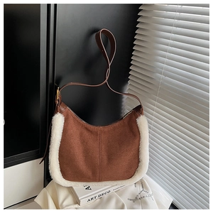 Dettaglio borsa a mezzaluna in camoscio marrone con bordo in peluche bianco e pelle